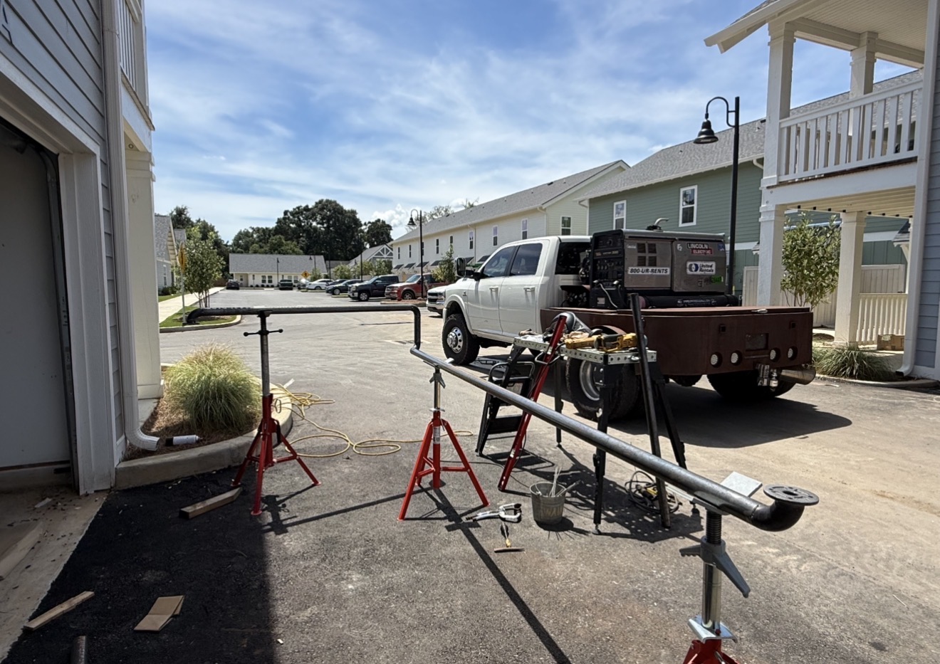 Mobile welding truck set up with pipe on stands at a commercial site